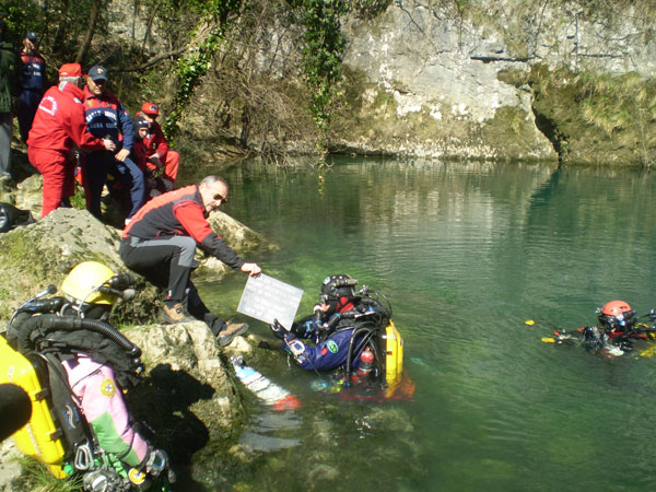 Il responsabile del Soccorso Speleologico del Veneto Giuseppe Minciotti consegna la targa che sarà collocata all'ingresso della grotta sommersa