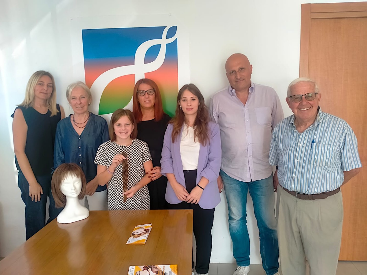 Foto di gruppo dei partecipanti alla conferenza stampa. Al centro la parruccaia Giada Pigatto
